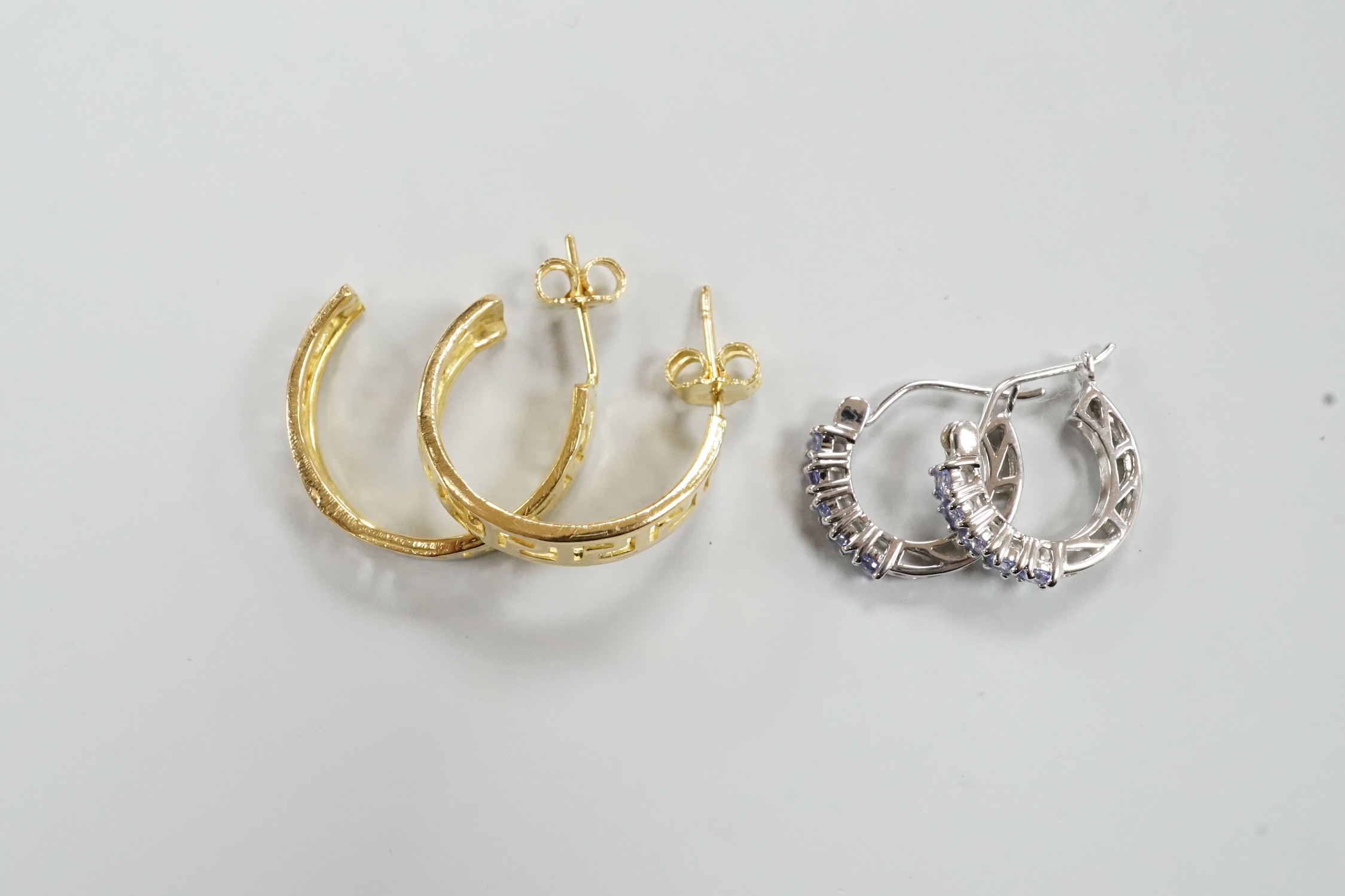 A modern pair of Middle Eastern? pierced yellow metal half hoop earrings, 23mm 6.7 grams and a modern pair of 14k white metal and gem set half hoop earrings, gross 2.5 grams.